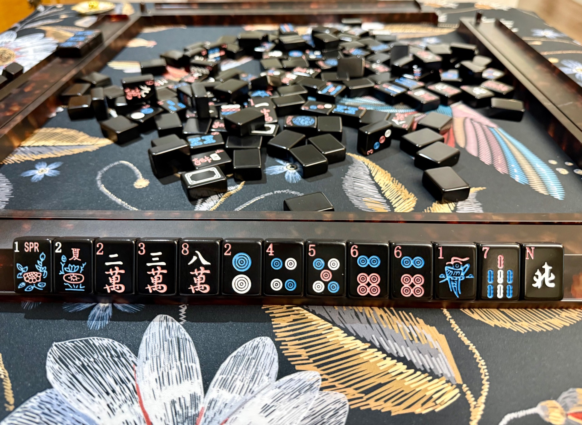 Mahjong tiles on embroidered table